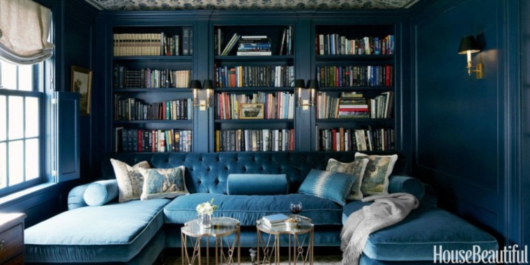 libreria design legno idea per sistemare spazio divano poltrona blu cuscini trendy