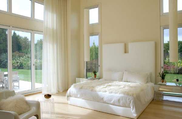 büyük duvarlar ve pencereler ile beyaz yatak odası