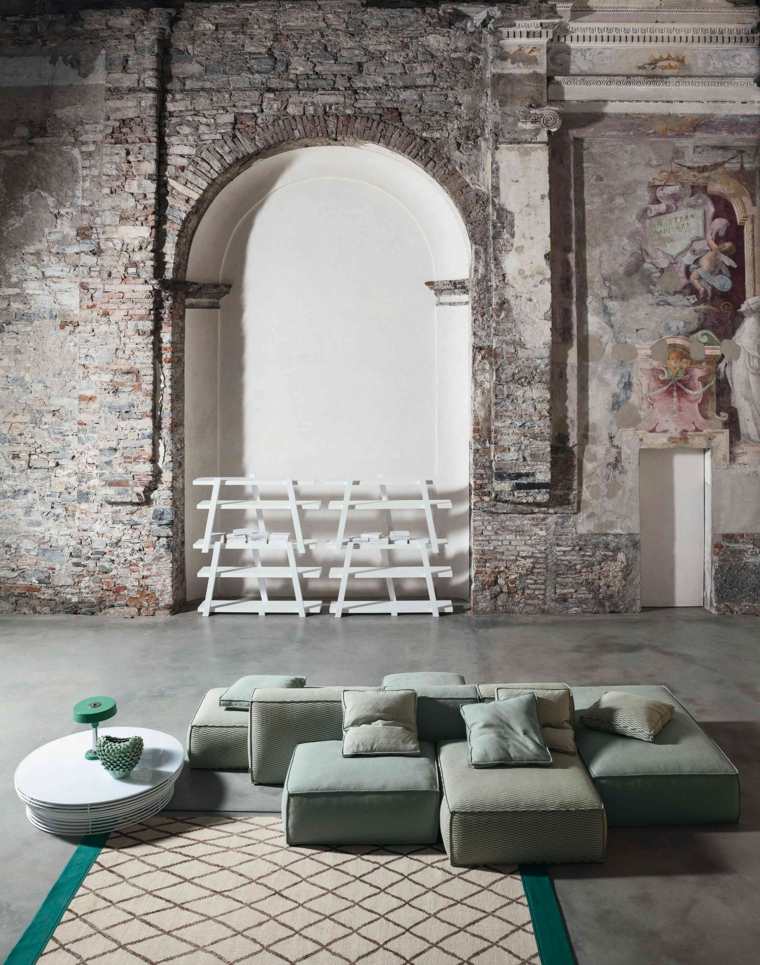 modern szekcionált kanapé ötlet nappali elrendezés kőfal dohányzóasztal szőnyeg grafikus minta