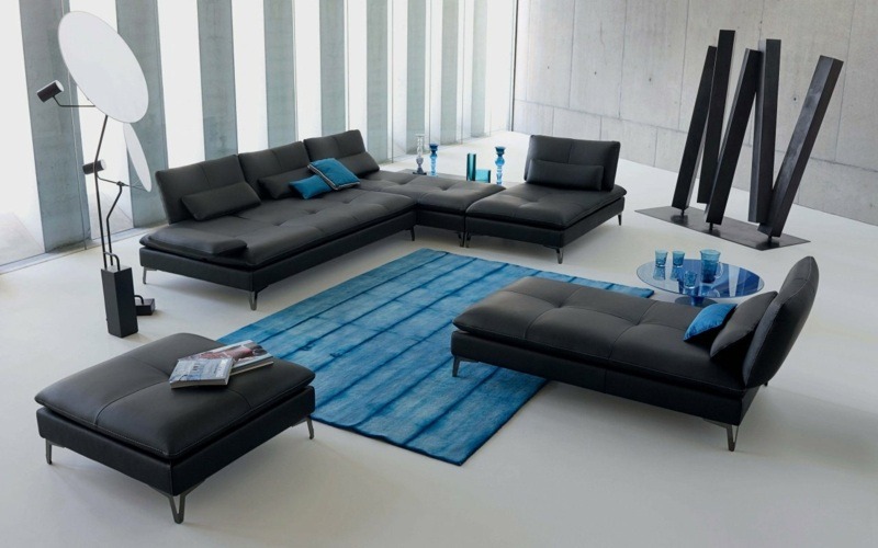 ideje za raspored dnevne sobe plava podna prostirka crna sofa plavi stolić za kavu crna kožna osmanska