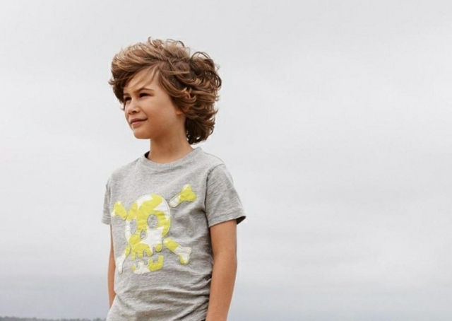 ragazzo dai capelli ricci vento taglio di capelli moderno da spiaggia californiana