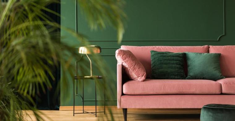 dizaino svetainė su žalia siena ir rožine sofa