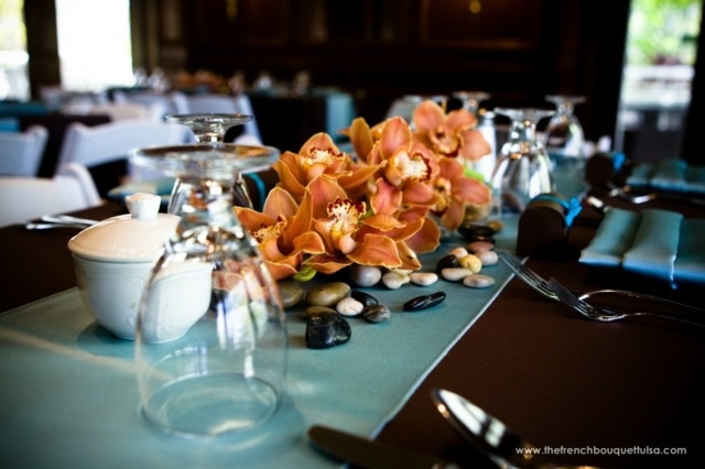 Centrinis stalas valgo gėlių kompozicijos oranžines orchidėjas