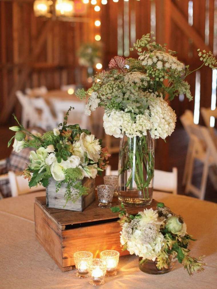 素朴なテーブルの花の結婚式の田園地帯を飾る
