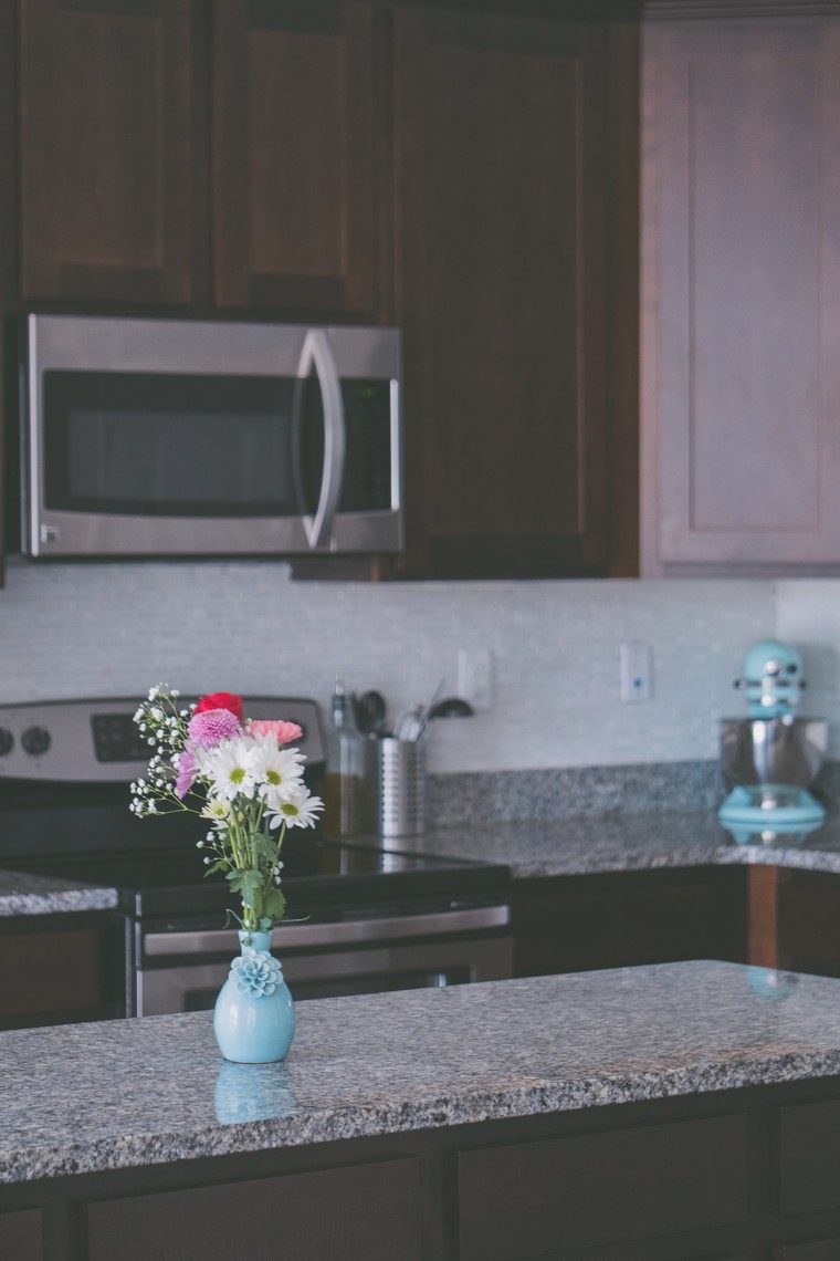 あなたのキッチンのアイデアを飾る花束の花キッチンワークトップの写真