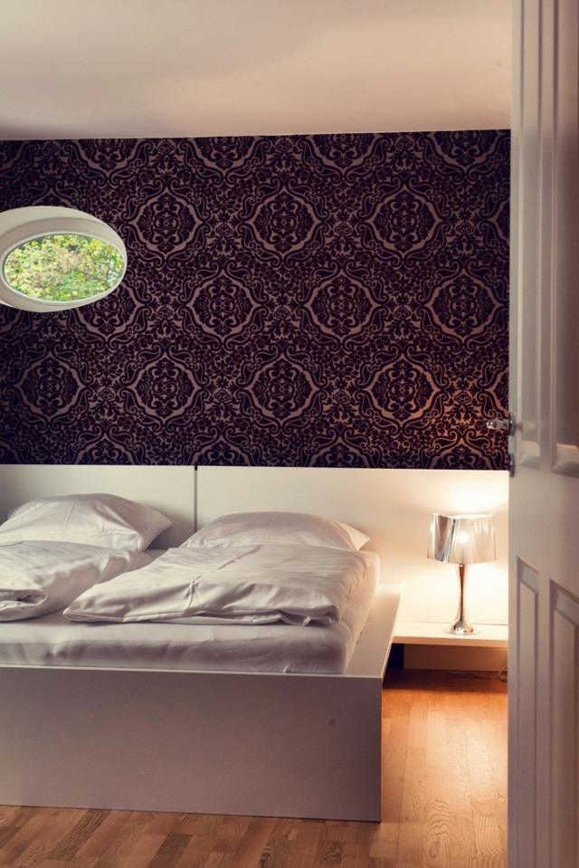 miegamojo dekoro idėjos-natūralios spalvos-tamsiai alyvinė-tapetai-raštai-patalynė-lova-balta-elegantiška-naktinis stalas