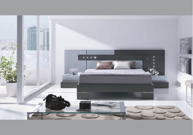 miegamojo dekoro idėjos-natūralios spalvos-smėlio spalvos kilimas-pilka-lova-medinė-galvos-lova-žemo stiklo stalas
