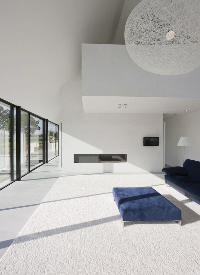 minimalistički suvremeni interijer čist stil bijela sofa niska fotelja niska bijela plava