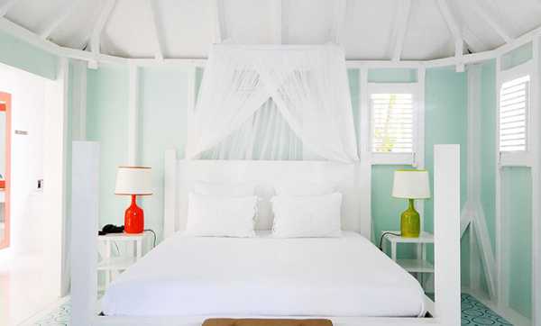 cama blanca sobre un fondo de paredes azules