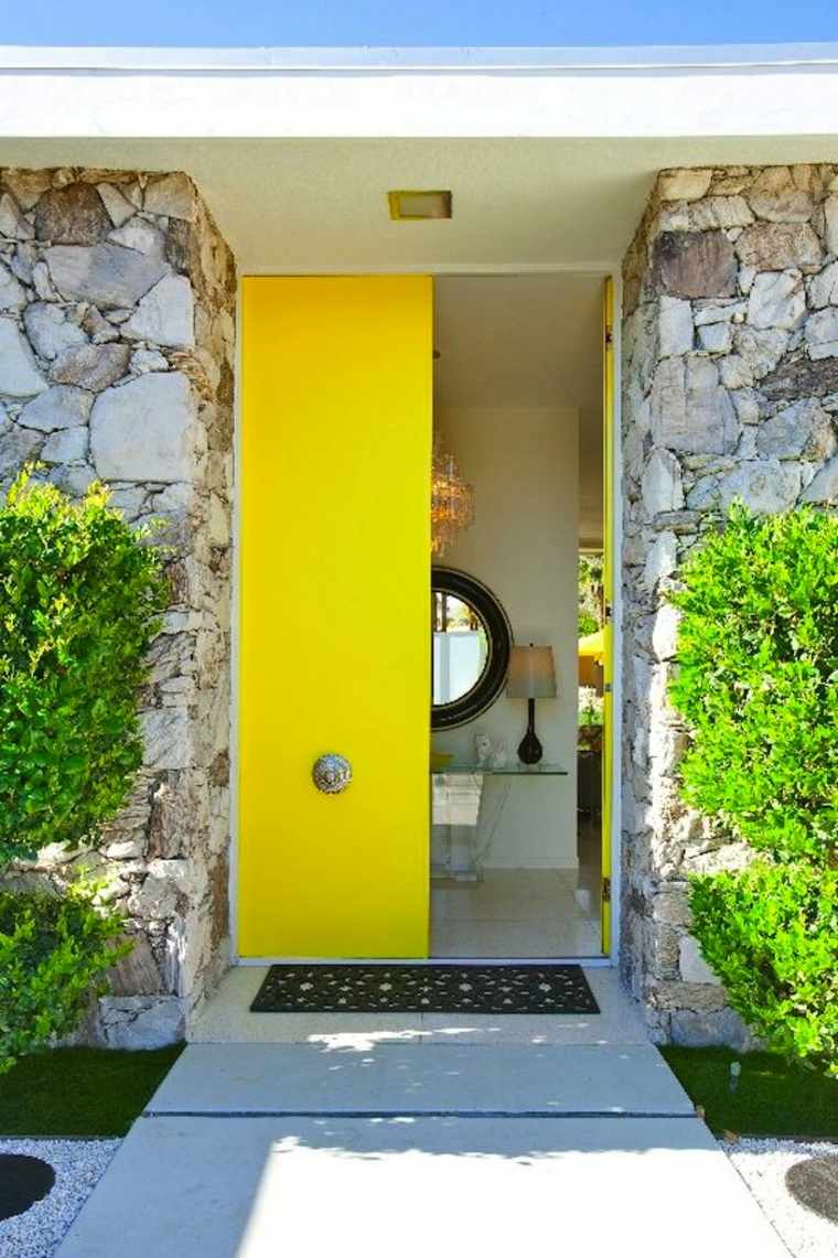 ryškiai geltonos medinės priekinių durų idėja, skirta apželdinti madingus išorės sienų akmenis