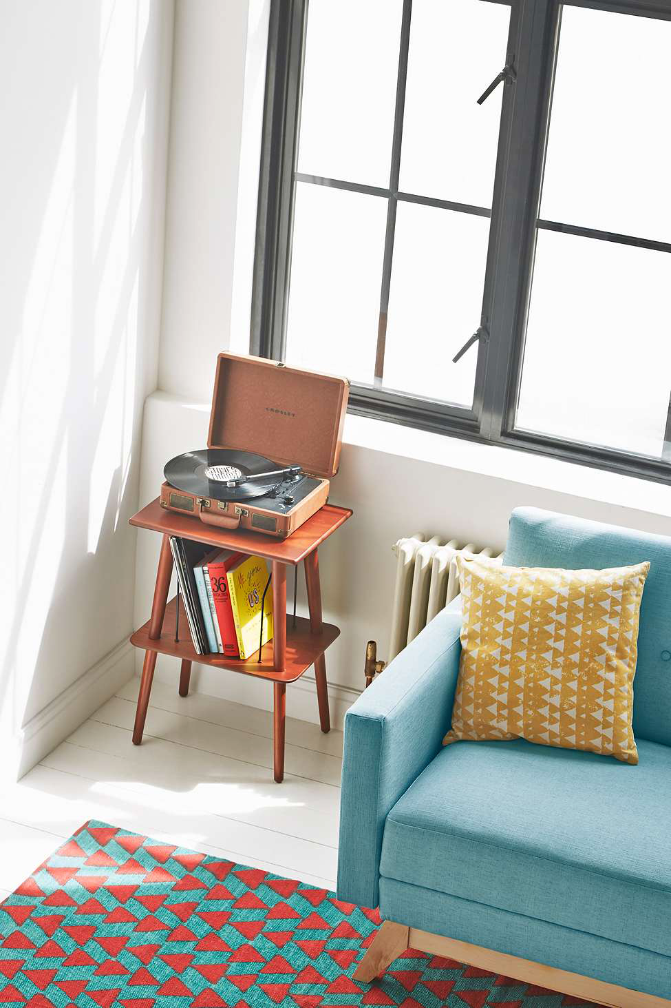 vinilo laikymo idėja interjeras svetainė medinis stalas mėlynos sofos pagalvėlės kiliminės grindys
