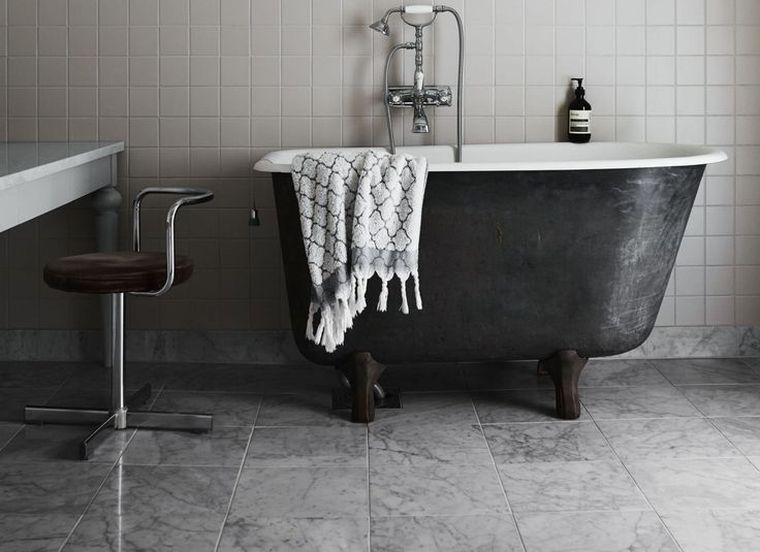 pilkas ir baltas vonios kambarys su juoda laisvai stovinčia vonia
