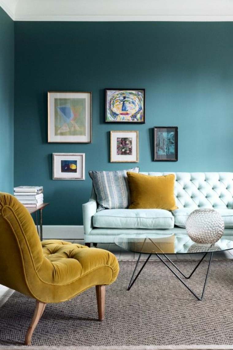 anatra blu soggiorno arredamento parete cornici tavolo in vetro poltrona giallo pastello