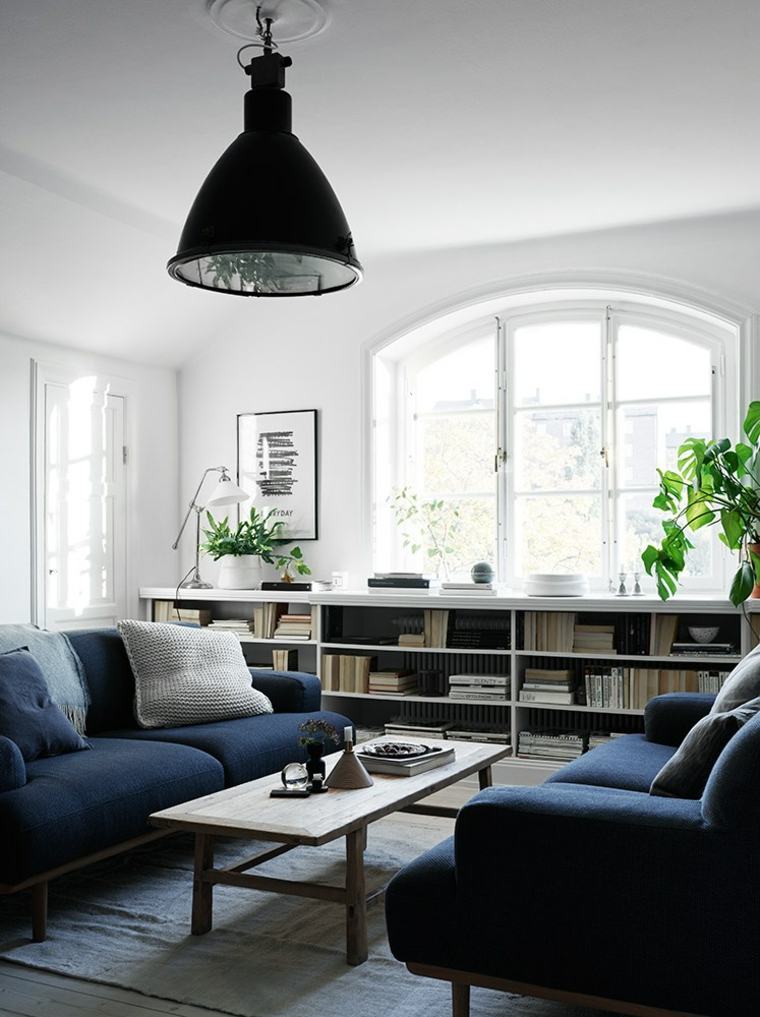 Interni soggiorno divano blu lampada a sospensione tavolino in legno