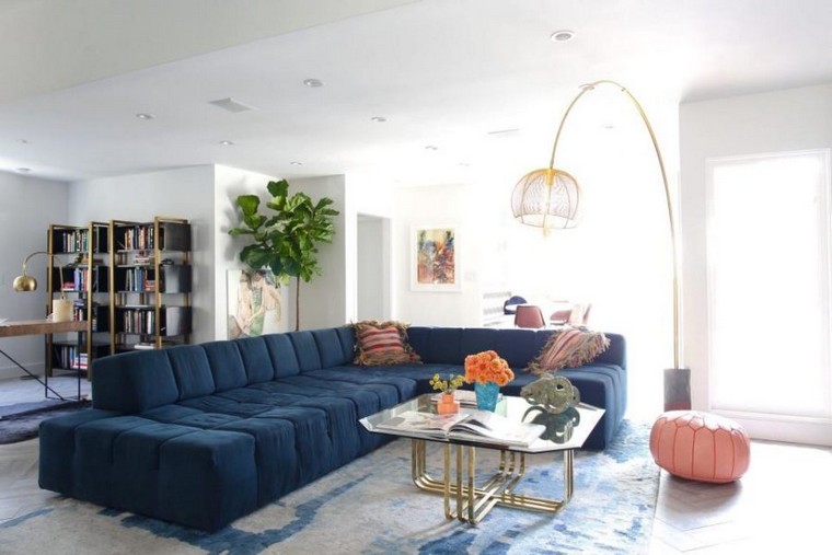 現代的なリビングルーム青いソファのアイデアクッションカーペット床コーヒーテーブルガラス照明ピンクプーフ