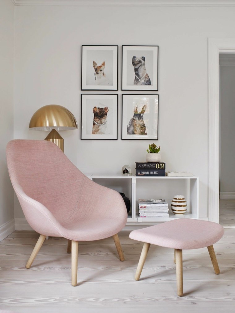 Soggiorno decorazione idea cornici da parete poltrona rosa ottoman