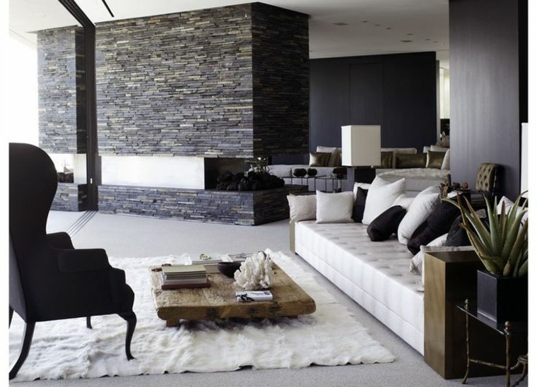interno soggiorno poltrona nera tappeto pavimento bianco muro di mattoni divano bianco