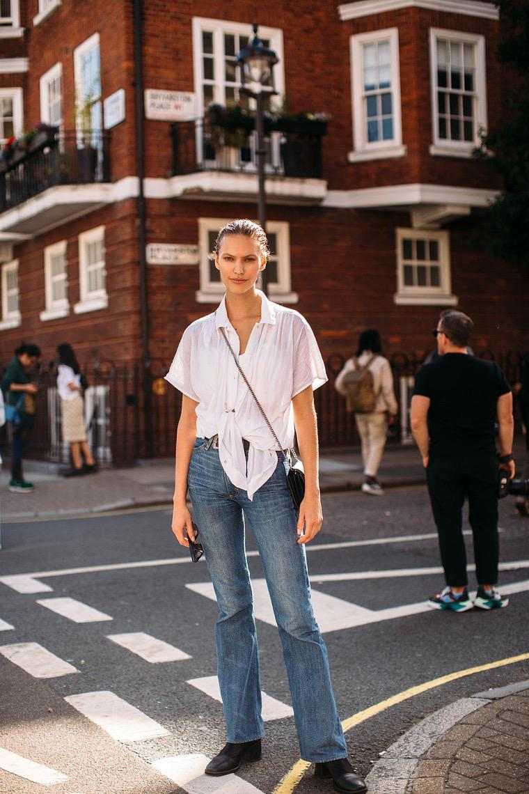 ロンドンのストリートスタイルの女性の白いシャツとジーンズ