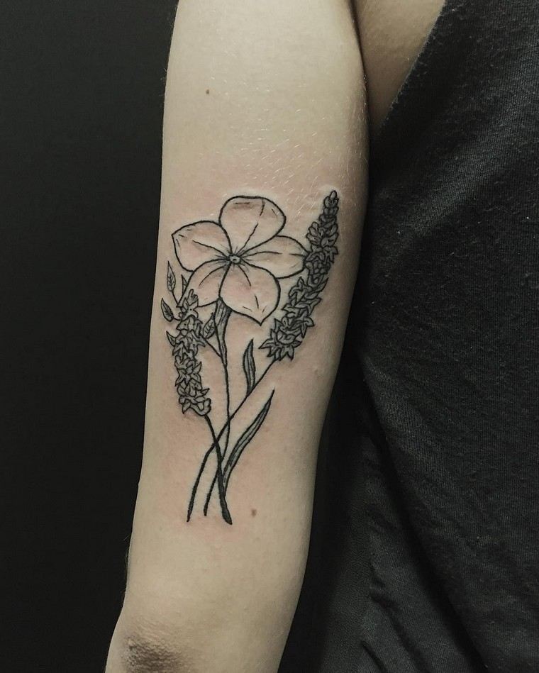 腕に花とラベンダーの入れ墨を持つ男