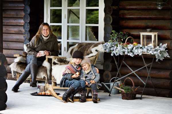 familia en el porche de una casa de madera